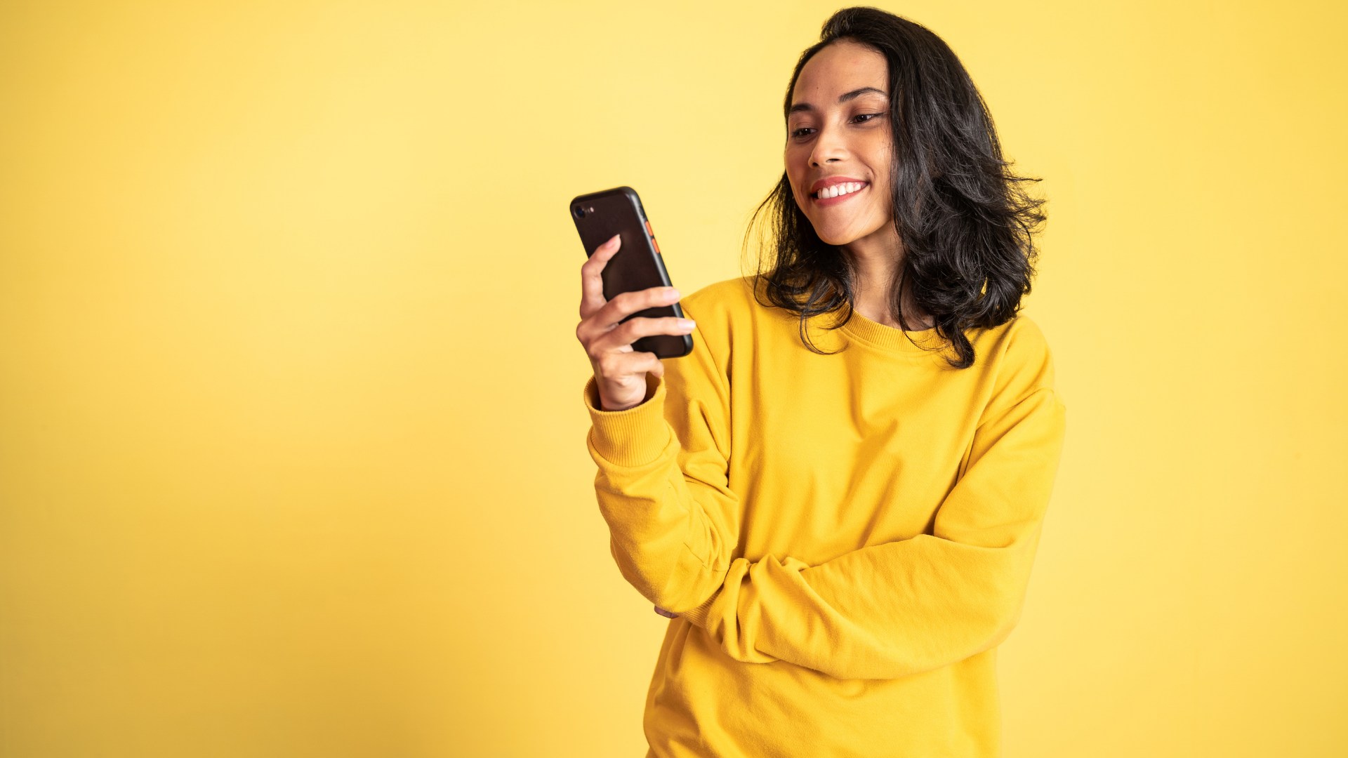 Telefonuyla etkileşimini takip eden bir kişi